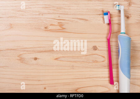 electric and manual toothbrushes on the light wooden background with copy space for your text. Top view Stock Photo