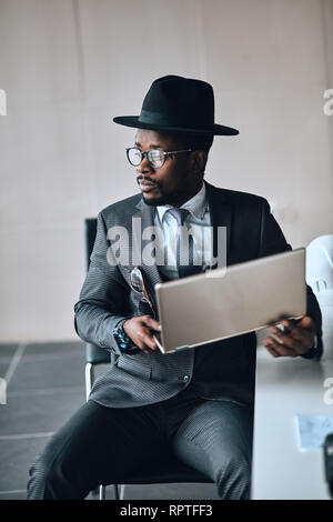 thoughtful manager is holding laptop and looking aside. close up photo Stock Photo