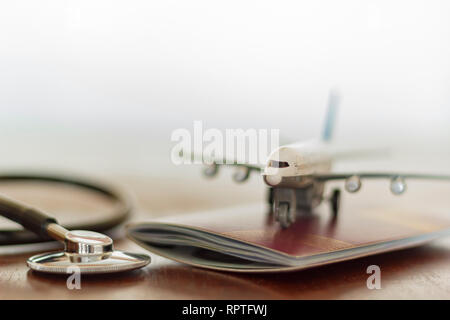 Stethoscope , passport document and airplane: Medical Travel concept Stock Photo