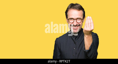 Middle age priest man wearing catholic robe Doing Italian gesture with hand and fingers confident expression Stock Photo