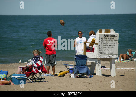 people tossing a football on the beach on Lake Erie, Ashtabula, Oh Stock Photo