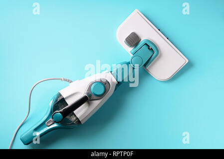 Steam cleaner mop on blue background. Top view, flat lay. Banner with copy space. Cleaning service concept. Stock Photo