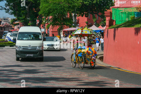 A colourful trishaw in front of the Christ Church, Malacca (Melaka), Malaysia Stock Photo