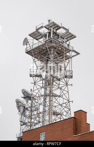 Microwave communication or telecommunications tower sitting atop a large brick building or structure in Montgomery, Alabama USA. Stock Photo
