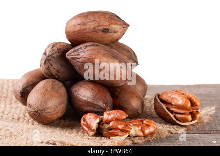 a bunch of pecan nuts on the old board with white background Stock Photo