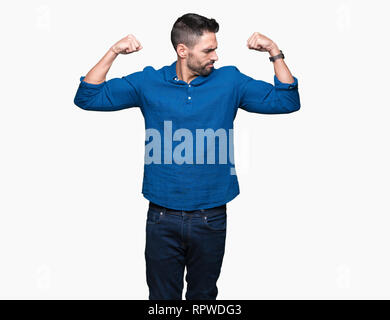 Young handsome man over isolated background showing arms muscles smiling proud. Fitness concept. Stock Photo