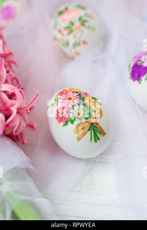 Beautiful Easter eggs decorated with paper napkins and flowers on white tulle background; decoupage technique Stock Photo