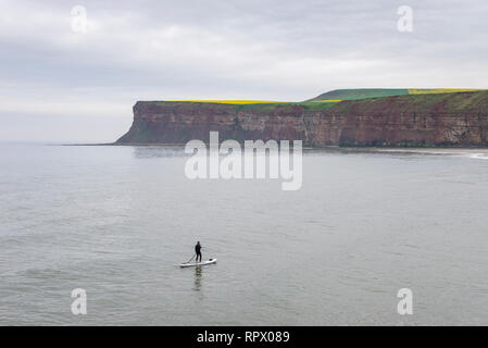 Man on a paddle board in the sea at Saltburn-by-the-sea, North Yorkshire, England. Stock Photo