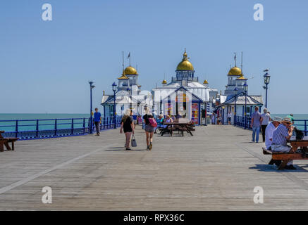 Eastbourne, Sussex, Uk - August 1, 2018: View of the end of the pier with people strolling and sitting at picnic tables.  Taken on a beautiful sunny s Stock Photo