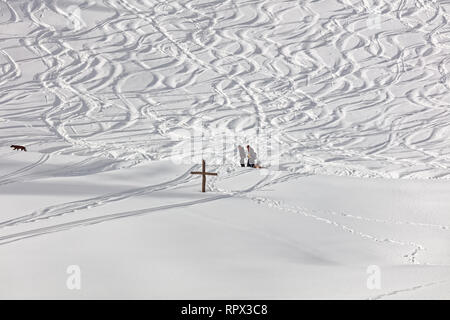 Sledders with sled and dogwith snow tracks in background at Hinterbergalpe - Vorarlberg, Austria Stock Photo