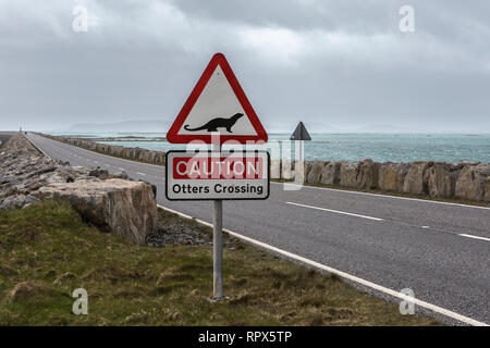 'Caution Otters Crossing' road sign on the approach to the causeway from South Uist to Eriskay, Outer Hebrides, Scotland. Stock Photo