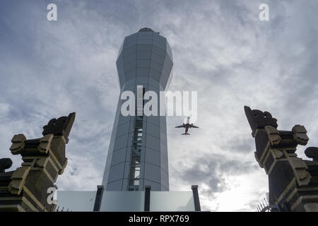 Denpasar, Bali - January 12 2018: Lighthouse at Benoa Harbour. When wind blow from West , ,planes which that going to land in Ngurah Rai Airport Stock Photo