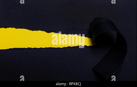 Black torn paper and place for text with a yellow background Stock Photo