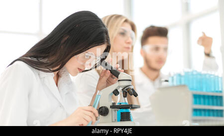 female scientist uses a microscope for research in a laboratory Stock Photo