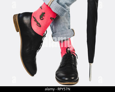 Businessman, trendy shoes, blue jeans and bright, colorful socks on a white, isolated background. Close-up. Style, fashion, beauty, elegance Stock Photo