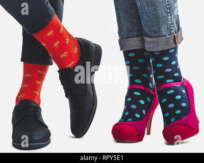 Men's and women's trendy shoes, blue trousers and bright, multicolored socks on a white, isolated background. Close-up. Going forward. Style, fashion, Stock Photo