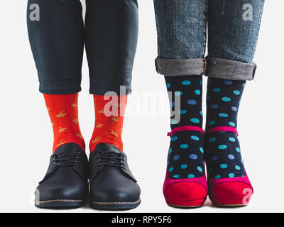 Men's and women's trendy shoes, blue trousers and bright, multicolored socks on a white, isolated background. Close-up. Going forward. Style, fashion, Stock Photo