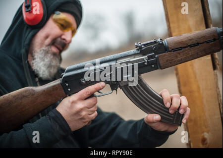 Close-up detail view of kalashnikov riffle machine gun cartridge bullet clip reloading. Load and unload ak47 Stock Photo