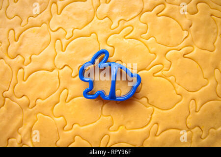 Baking Easter biscuits. Easter symbol concept. Process of cutting rabbit-shaped cookies Stock Photo