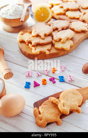 Happy Easter greeting. Baking Easter bunnies. Cookies with ingredients and bright greeting Stock Photo