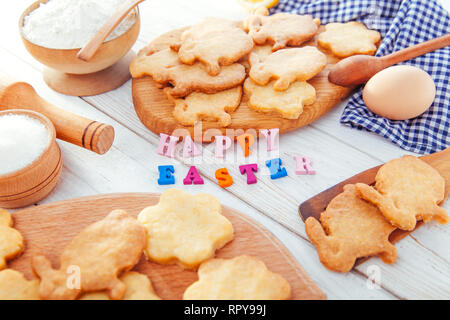 Happy Easter greeting. Baking Easter bunnies. Cookies with ingredients and bright message Stock Photo
