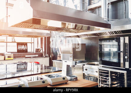 Professional kitchen interior of restaurant. Modern equipment and devices made of stainless steel. Empty kitchen in the morning. Stock Photo