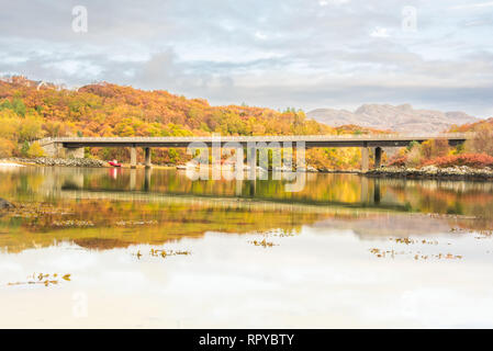 The bridge carrying the A830 road over the River Morar, near Morar, Highlands of Scotland - autumn scenery with orange leaves and trees reflected in w Stock Photo