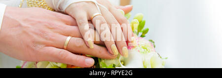 Close up wedding flowers bouquet hands of unrecognizable bride and groom, copyspace for text, wedding salon, ceremony preparations ad gowns and suits, Stock Photo