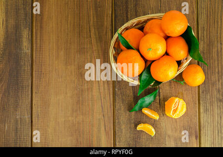 Bunch of fresh tangerines, clementines or mandarins in basket and leaves close up. Studio Photo Stock Photo