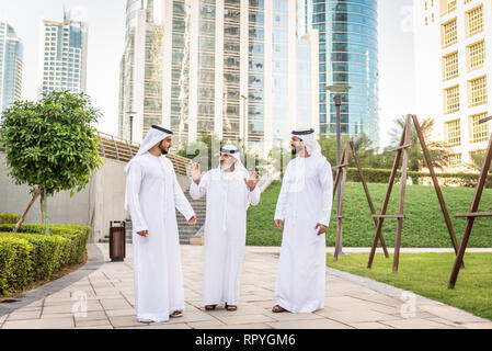 Group of arabian businessmen with kandura meeting outdoors in UAE - Middle-eastern men in Dubai Stock Photo