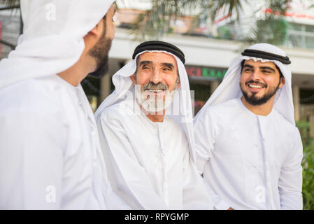 Group of arabian businessmen with kandura meeting outdoors in UAE - Middle-eastern men in Dubai Stock Photo