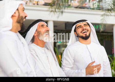 Group of arabian businessmen with kandura meeting outdoors in UAE - Middle-eastern men in Dubai Stock Photo