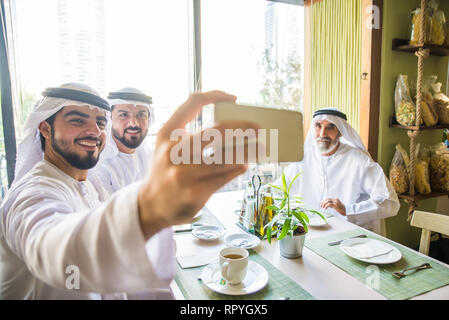 Group of middle eastern men wearing kandora bonding in a cafè restarant in Dubai Stock Photo