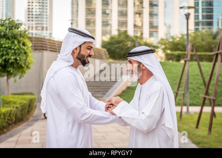 Group of arabian businessmen with kandura meeting outdoors in UAE - Middle-eastern men in Dubai Stock Photo