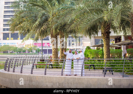 Group of arabian businessmen with kandura meeting outdoors in UAE - Middle-eastern men in Dubai Stock Photo