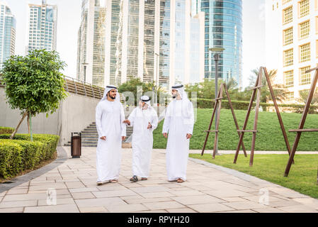 Group of arabian businessmen with kandura meeting outdoors in UAE - Middle-eastern men in Dubai Stock Photo