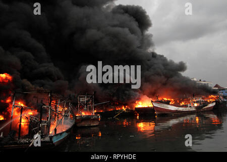 Jakarta, Indonesia. 23rd Feb, 2019. Boats are set on fire at Muara Baru Port in Jakarta, Indonesia. Feb. 23, 2019. Credit: Krisnada/Xinhua/Alamy Live News