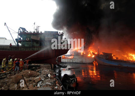 Jakarta, Indonesia. 23rd Feb, 2019. Firefighters try to extinguish the burning fishing boats at Muara Baru Port in Jakarta, Indonesia. Feb. 23, 2019. Credit: Krisnada/Xinhua/Alamy Live News