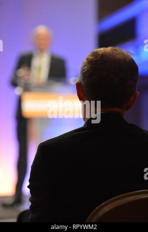 Hamilton, Scotland, UK. 23rd Feb, 2019. Pictured (left background) Sir Vince Cable MP leader of the UK Lib Dems and (right silhouetted) Willie Rennie MSP - leader of the Scottish Lib Dems. Vince Cable - Leader of the Liberal Democrat Party delivers his keynote speech on Brexit, Business and issues around Independence at the Scottish Liberal Democrat Party Spring Conference. Credit: Colin Fisher/Alamy Live News Stock Photo