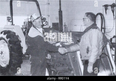 . Agri-news. Agriculture. January 1, 1990 For inmiediate release NW 4-H Council raises funds for tractor. Gordon Fuhr (left), president of the Northwest Regional 4-H Council, shakes hands with Allan Shenfield (right), a 4-H Foundation of Alberta director. Fuhr is presenting a tractor for the Alberta 4-H Centre at Battle Lake. The Northwest Regional 4-H Council's Steer-A-Day Committee has made a major contribution to the Alberta 4-H Council by purchasing a tractor for the Alberta 4-H Centre at Battle Lake. The tractor is a Ford 2120 four-wheel drive tractor complete with a front end loader and  Stock Photo
