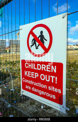 Warning sign on wire fence, children keep out of building site, Luton Airport, Luton, London, England, UK Stock Photo