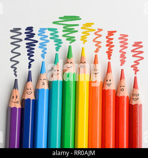 Smiling colored pencils with zigzag doodles on white background. Art supplies, emotion concept. Stock Photo
