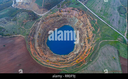 Abandoned ore mining mine with turquoise blue water on the outskirts of Tsar Asen, Bulgaria on sunset Stock Photo