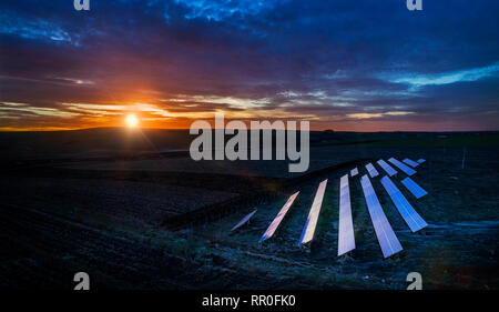 Solar panel produces green, environmentaly friendly energy from the setting sun. Aerial view from drone. Landscape picture of a solar plant that is lo Stock Photo