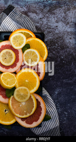 Sliced citrus fruits on black ground Stock Photo