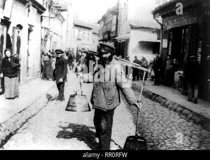 Jewish water carrier standing in street in Vilna, Russia 1922 Stock Photo