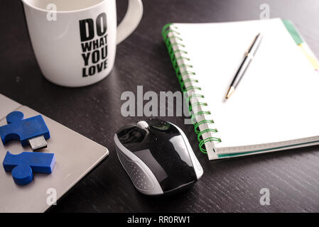 still life with blocknote, labtop, pen and a white mug of coffee over a black office desk. symbol of job Stock Photo