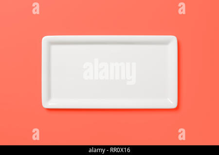 Empty white angular plate on pastel colored red pink background, view directly from above, clipping path included Stock Photo