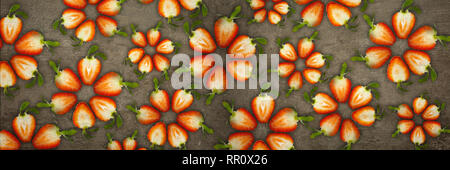 Creative flowers made of strawberries cut from below lit on a stone background Food concept Banner Stock Photo