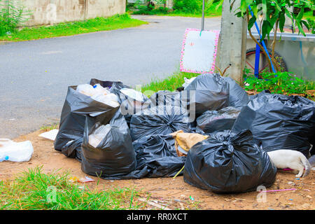 Pile black garbage roadside and Rain drops on the bag  in the city with copy space add text Stock Photo